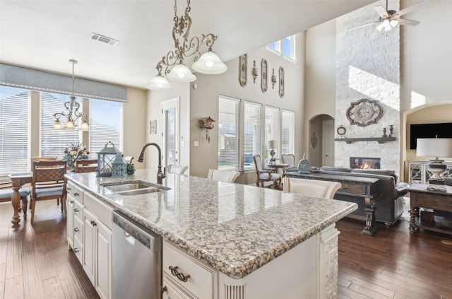 kitchen with an island with sink, a sink, dark wood-type flooring, dishwasher, and open floor plan