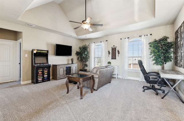 carpeted living room featuring a tray ceiling, baseboards, and visible vents