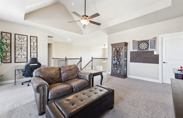 carpeted living area with visible vents, baseboards, a raised ceiling, and vaulted ceiling