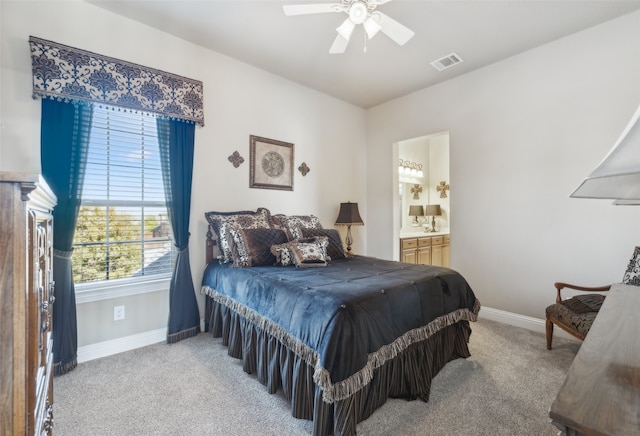 bedroom with visible vents, ceiling fan, baseboards, light carpet, and ensuite bath