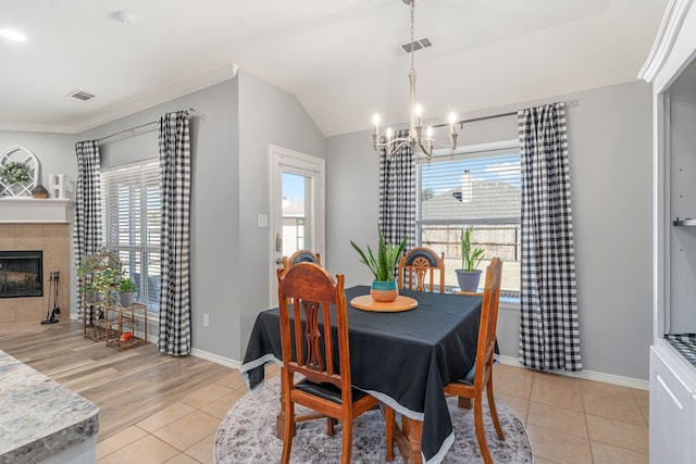 dining room with a fireplace, visible vents, and a wealth of natural light