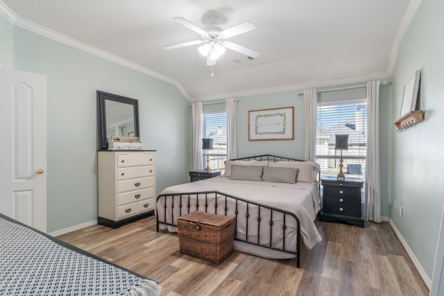 bedroom with visible vents, crown molding, baseboards, and wood finished floors