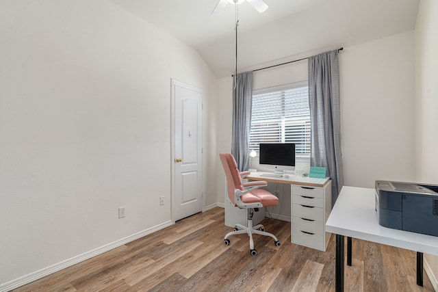 office space featuring vaulted ceiling, baseboards, and wood finished floors