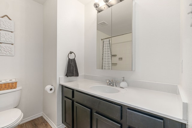 full bathroom with visible vents, baseboards, toilet, wood finished floors, and vanity