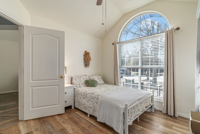 bedroom with light wood-type flooring, baseboards, ceiling fan, and vaulted ceiling