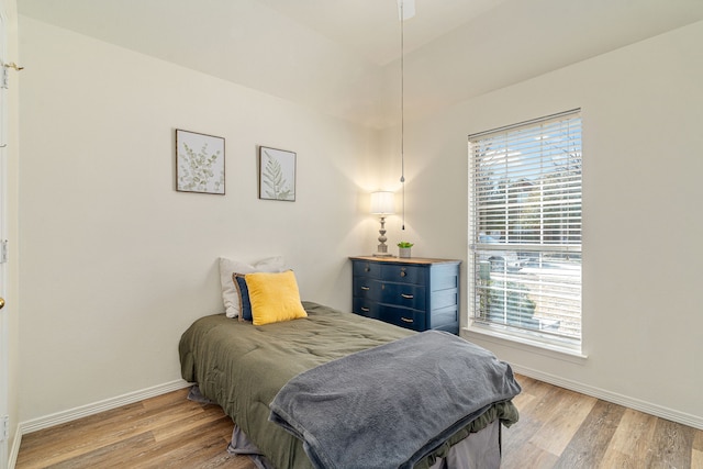 bedroom with baseboards and light wood finished floors