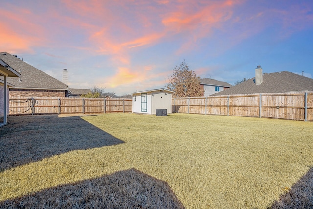 view of yard featuring an outdoor structure, a storage unit, and a fenced backyard