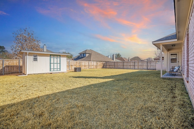 view of yard featuring an outdoor structure, central air condition unit, a fenced backyard, and a shed