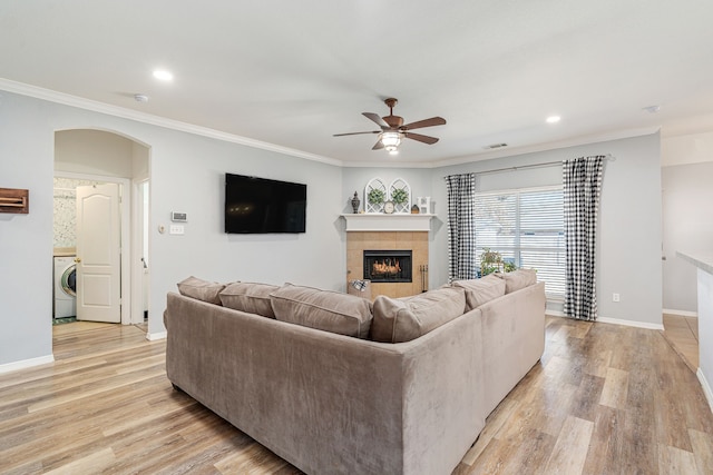 living area with washer / clothes dryer, light wood-style floors, and ornamental molding