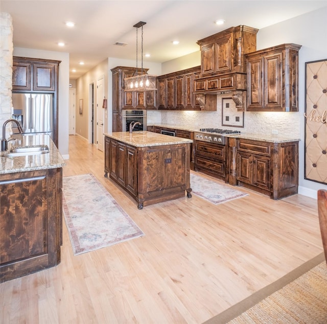 kitchen with a center island with sink, backsplash, stainless steel appliances, and a sink