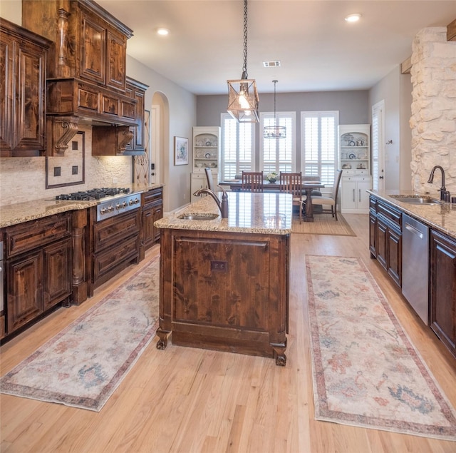 kitchen featuring a sink, visible vents, light wood-type flooring, and appliances with stainless steel finishes