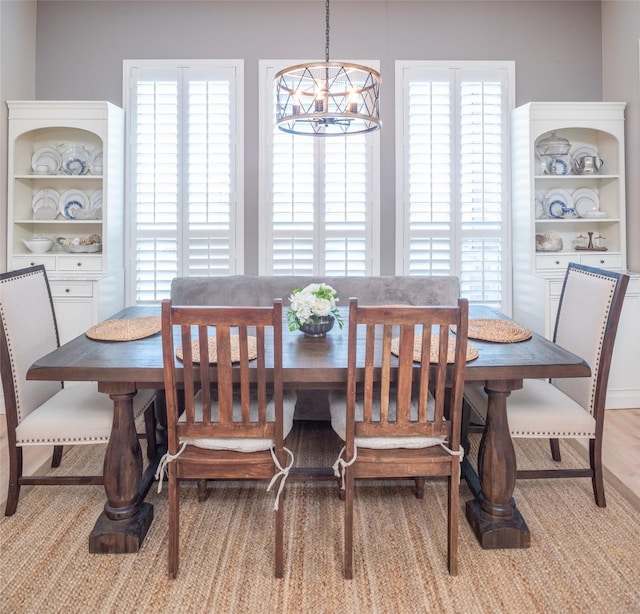 dining area featuring a wealth of natural light, a notable chandelier, and wood finished floors