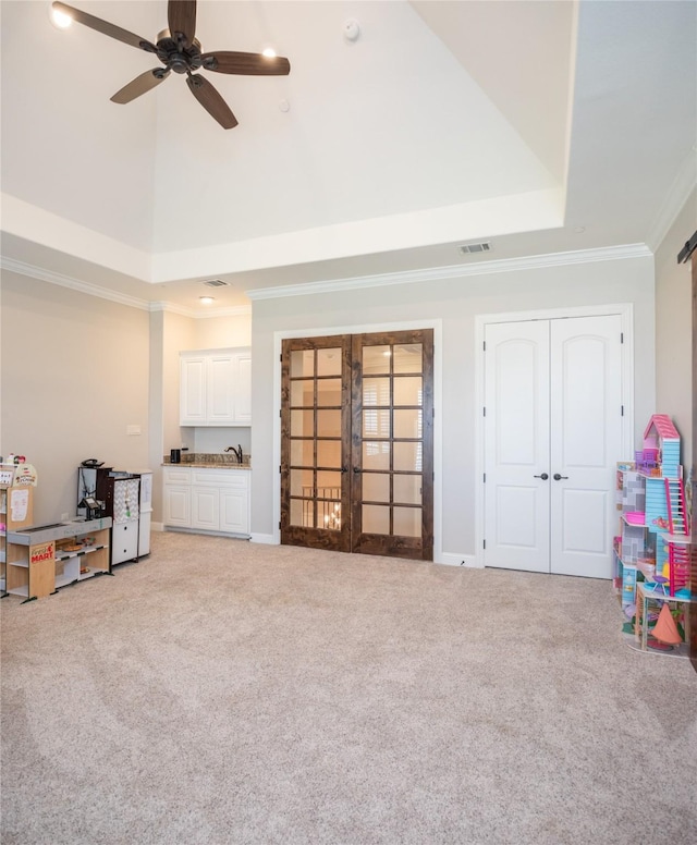 rec room with visible vents, ornamental molding, carpet flooring, a ceiling fan, and a sink