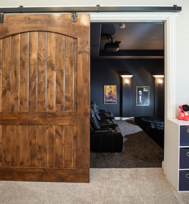 cinema room featuring a barn door and carpet