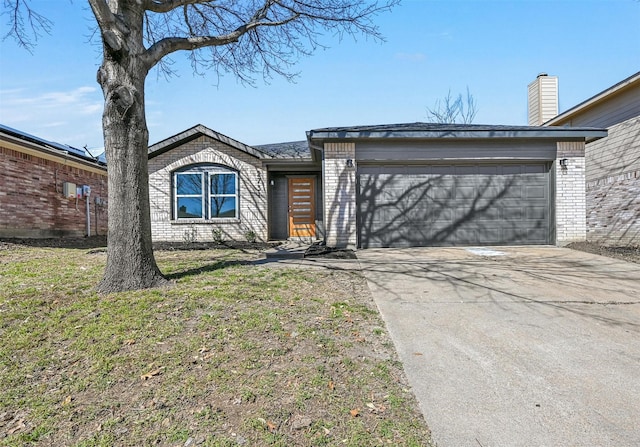 view of front of home featuring concrete driveway, an attached garage, brick siding, and a front lawn