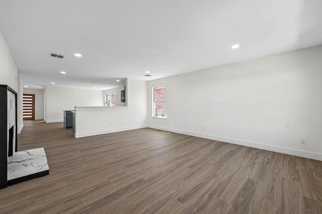 unfurnished living room featuring dark wood-style floors, visible vents, recessed lighting, and baseboards