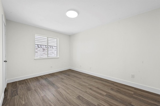 unfurnished room featuring dark wood-style floors and baseboards