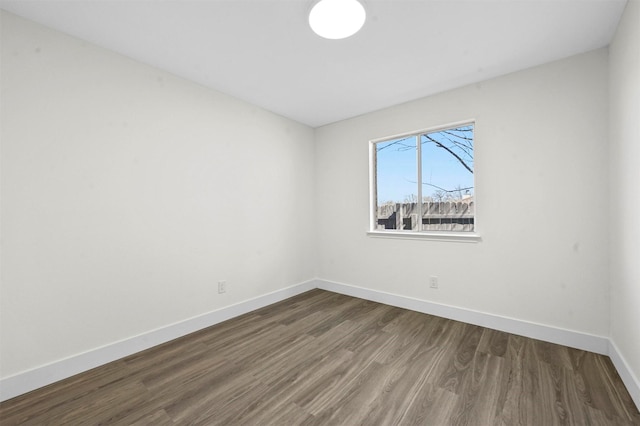 empty room with baseboards and dark wood-style flooring