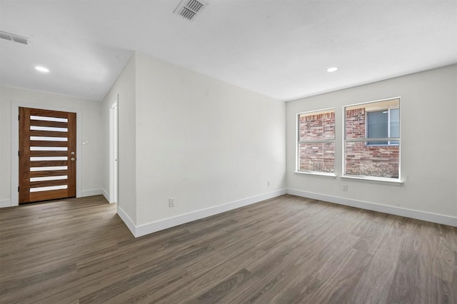 empty room featuring visible vents, recessed lighting, baseboards, and dark wood-style flooring