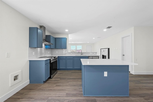 kitchen featuring dark wood finished floors, stainless steel range with electric cooktop, light countertops, blue cabinets, and backsplash