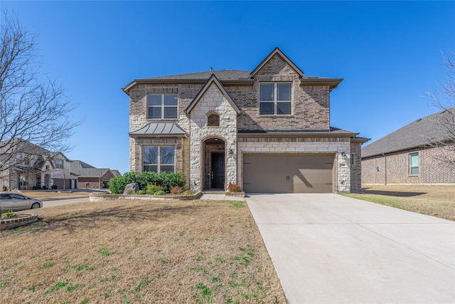 french country style house featuring brick siding, an attached garage, concrete driveway, and a front lawn