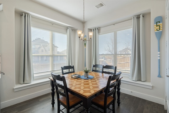 dining room with an inviting chandelier, dark wood-style floors, visible vents, and baseboards