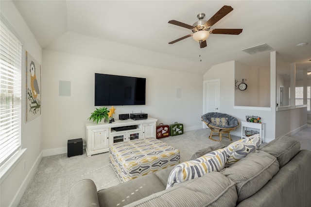 living room featuring visible vents, baseboards, light colored carpet, ceiling fan, and vaulted ceiling