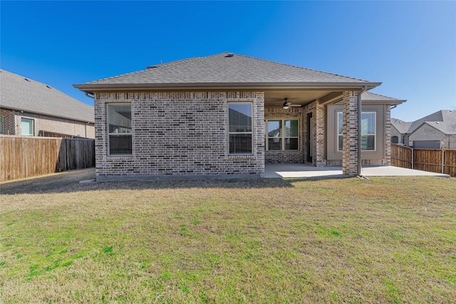 rear view of property featuring a yard, a fenced backyard, a ceiling fan, and a patio area