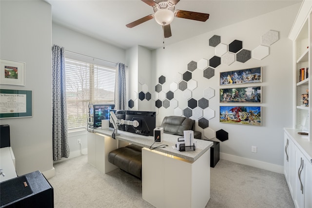 home office featuring baseboards, light carpet, and a ceiling fan