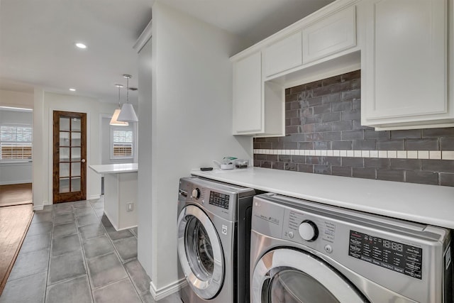 washroom with washer and dryer, cabinet space, plenty of natural light, and light tile patterned floors