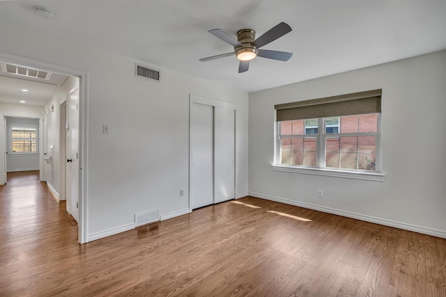 unfurnished bedroom with visible vents, baseboards, and wood finished floors