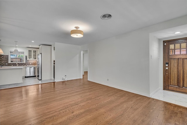 unfurnished living room featuring light wood-style flooring, recessed lighting, baseboards, and visible vents