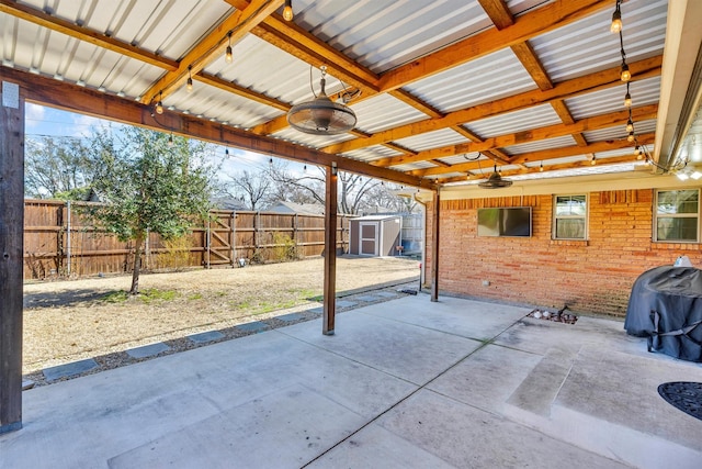 view of patio with an outdoor structure, a storage unit, fence, and ceiling fan