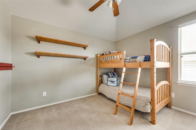 carpeted bedroom with baseboards, a ceiling fan, and vaulted ceiling