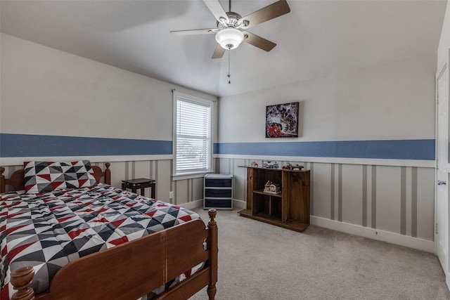 carpeted bedroom featuring wainscoting and ceiling fan