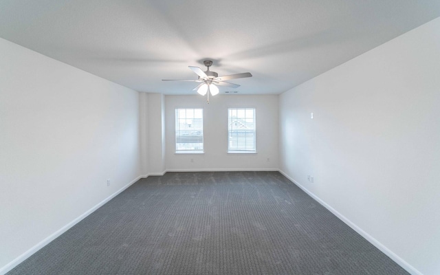 empty room featuring a ceiling fan, baseboards, and dark colored carpet