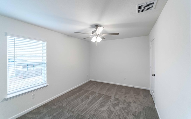 carpeted empty room featuring a ceiling fan, plenty of natural light, baseboards, and visible vents