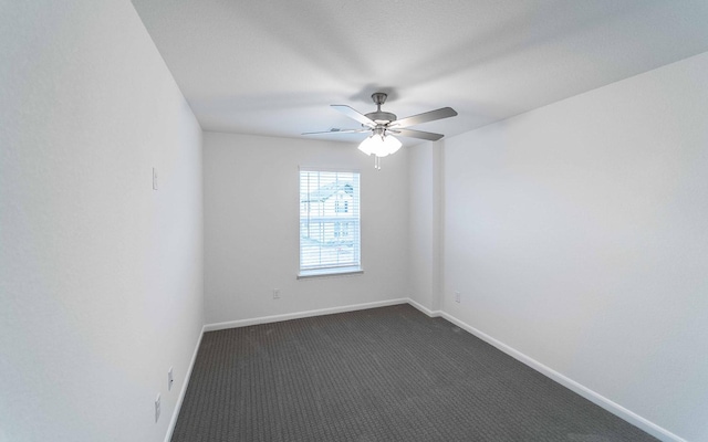 empty room featuring a ceiling fan, baseboards, and dark colored carpet