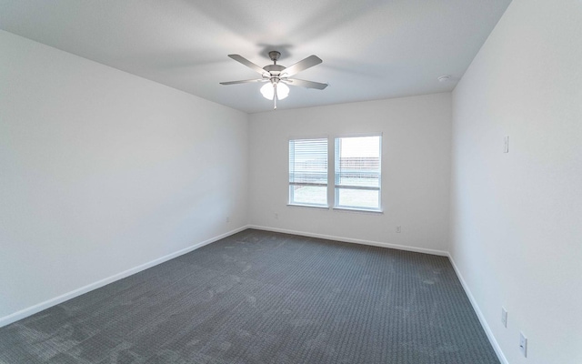 empty room with a ceiling fan, baseboards, and dark carpet