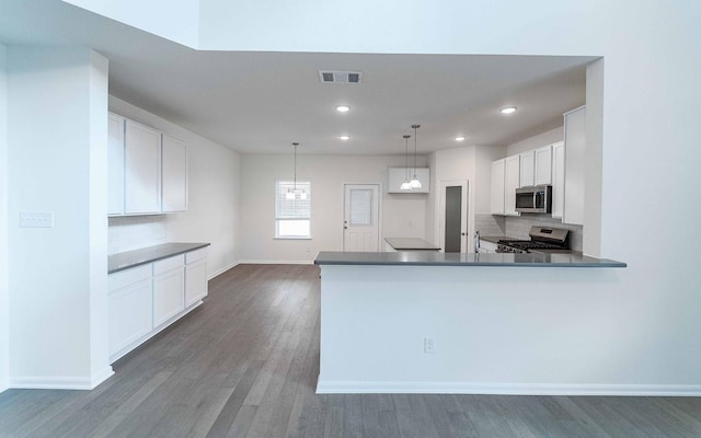 kitchen featuring visible vents, tasteful backsplash, dark wood finished floors, appliances with stainless steel finishes, and white cabinets