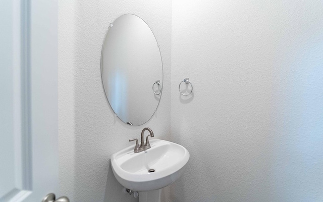 bathroom with a sink and a textured wall