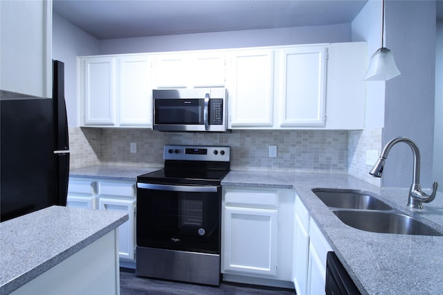 kitchen with tasteful backsplash, appliances with stainless steel finishes, white cabinetry, and a sink