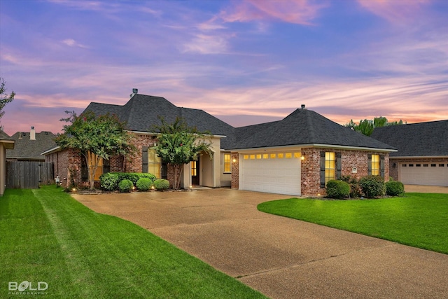 french country home with brick siding, a front lawn, and driveway