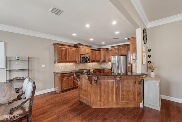 kitchen with visible vents, tasteful backsplash, stainless steel appliances, a peninsula, and brown cabinetry