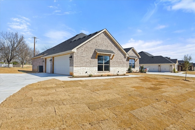 view of front of home with brick siding, stone siding, and a garage