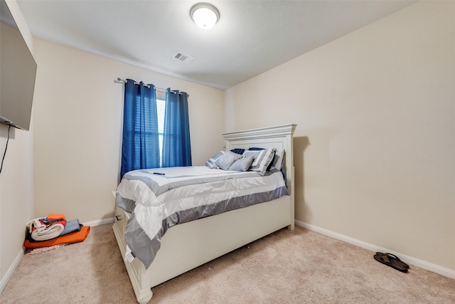 bedroom with visible vents, light colored carpet, and baseboards