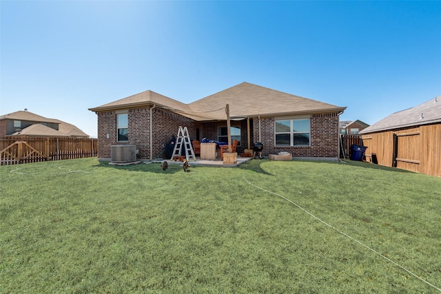 rear view of house featuring brick siding, central AC, a lawn, a fenced backyard, and a patio