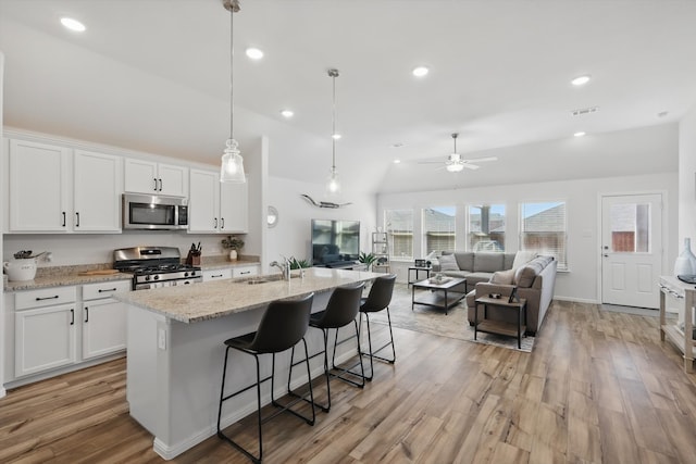 kitchen featuring a sink, light wood-type flooring, appliances with stainless steel finishes, and white cabinets