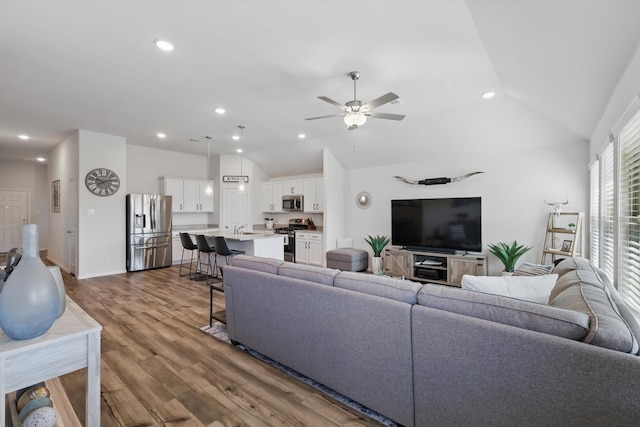 living area with a ceiling fan, dark wood finished floors, recessed lighting, baseboards, and vaulted ceiling