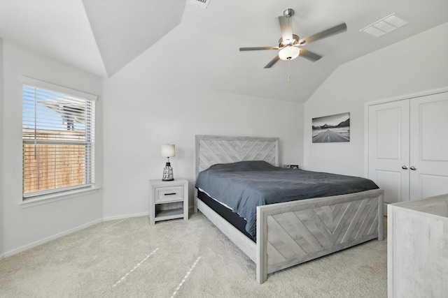 carpeted bedroom featuring visible vents, baseboards, a closet, lofted ceiling, and ceiling fan